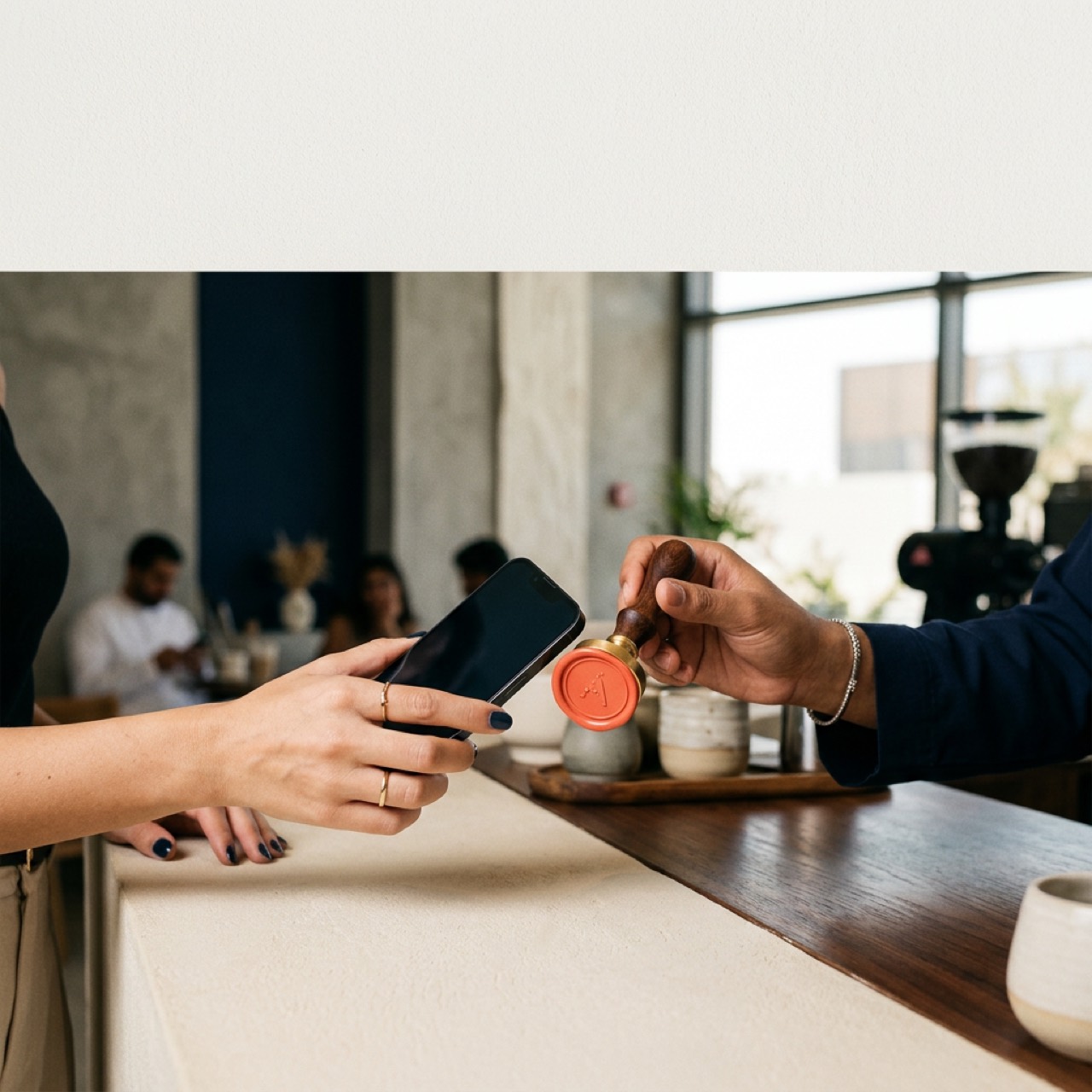A customer paying with their phone at a UAE specialty coffee bar, a flat white on the counter.